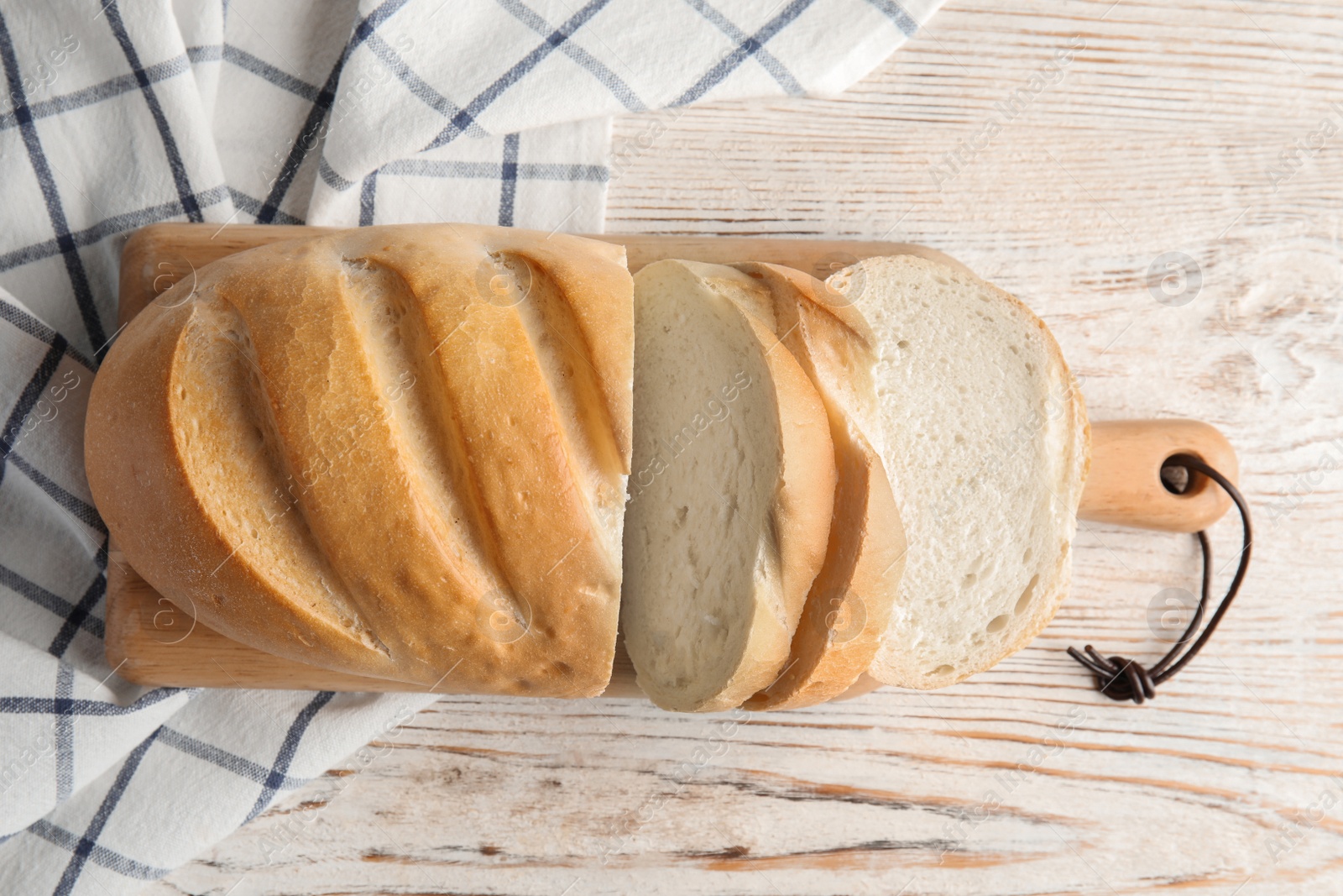 Photo of Board with tasty bread on wooden background, top view