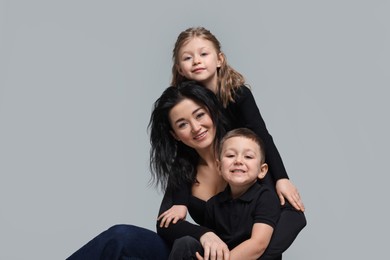 Photo of Little children with their mother on grey background