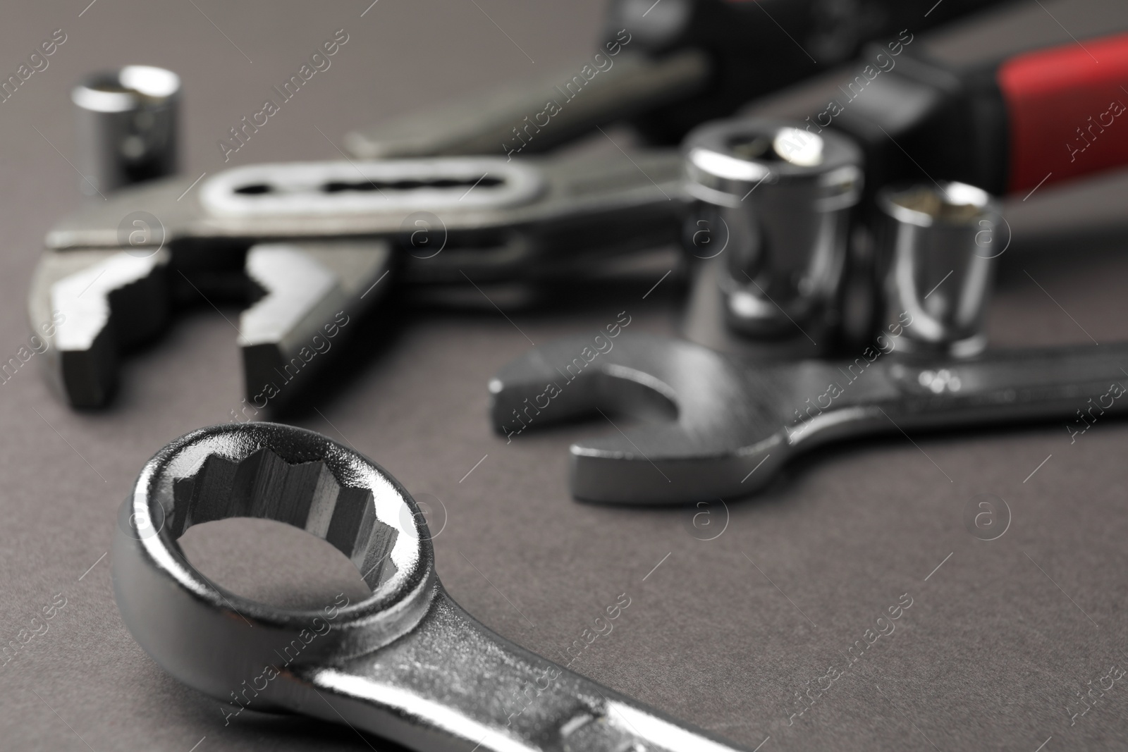 Photo of Auto mechanic's tools on grey background, closeup