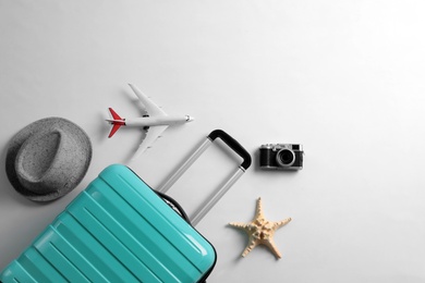 Photo of Flat lay composition with suitcase and travel accessories on grey background. Summer vacation