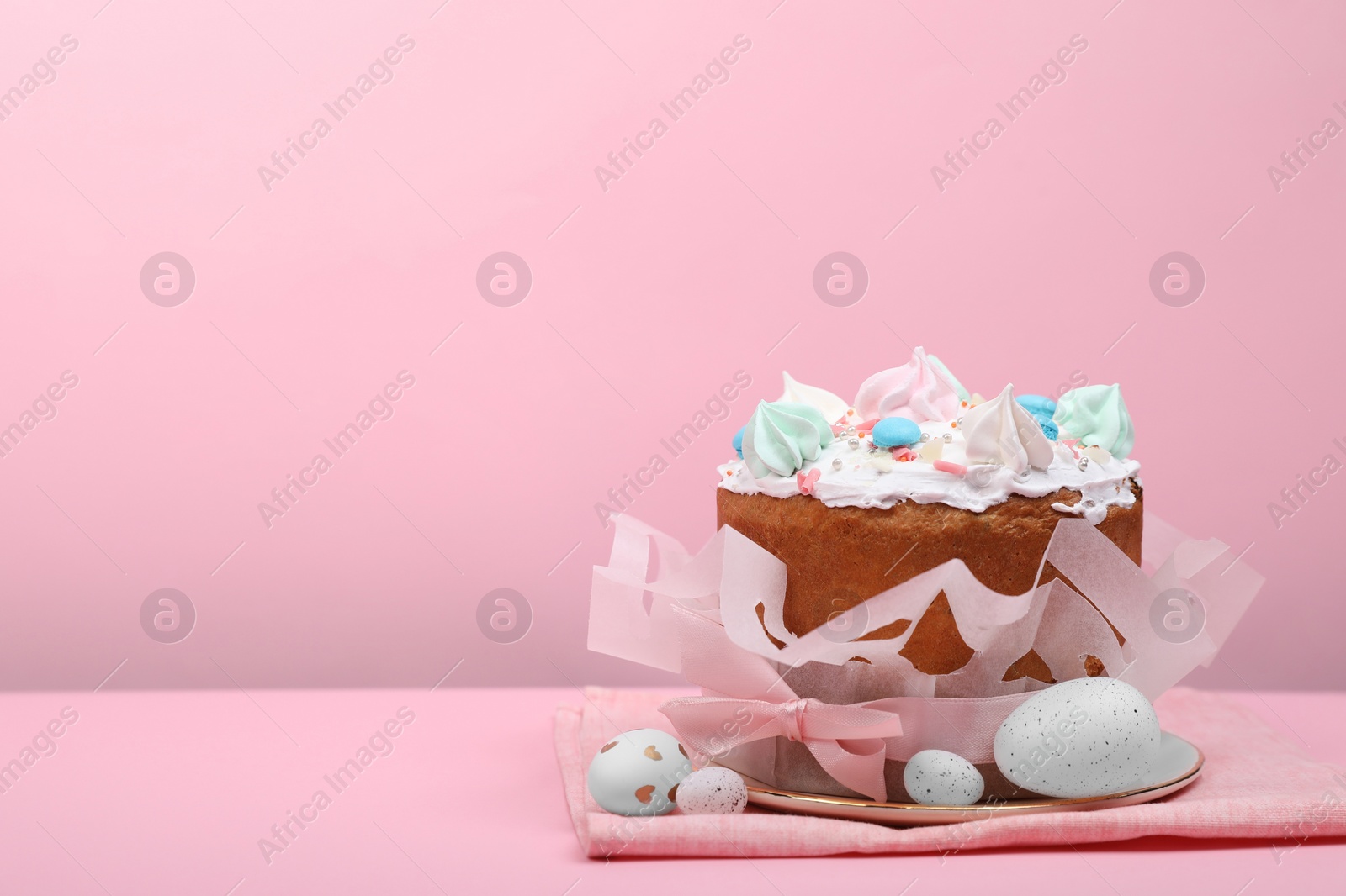 Photo of Traditional Easter cake with meringues and painted eggs on pink background, space for text