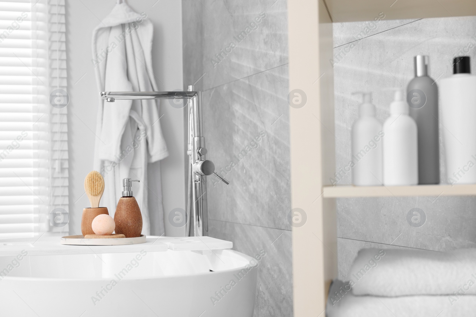 Photo of Different personal care products and accessories on bath tub in bathroom