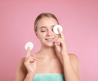 Photo of Beautiful young woman with cotton pads on pink background