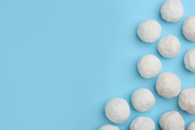 Snowballs on light blue background, flat lay. Space for text