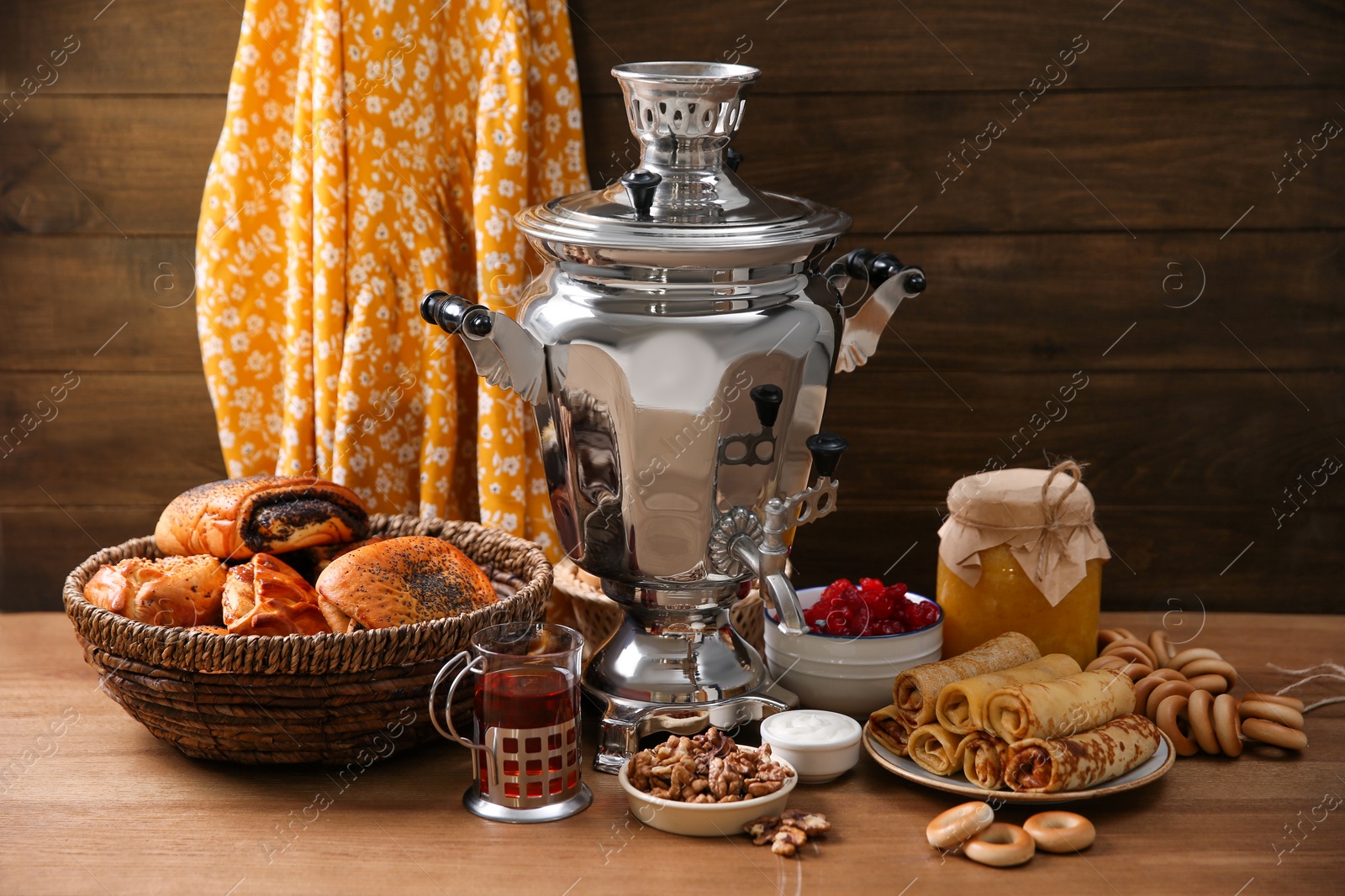 Photo of Traditional Russian samovar and treats on wooden table