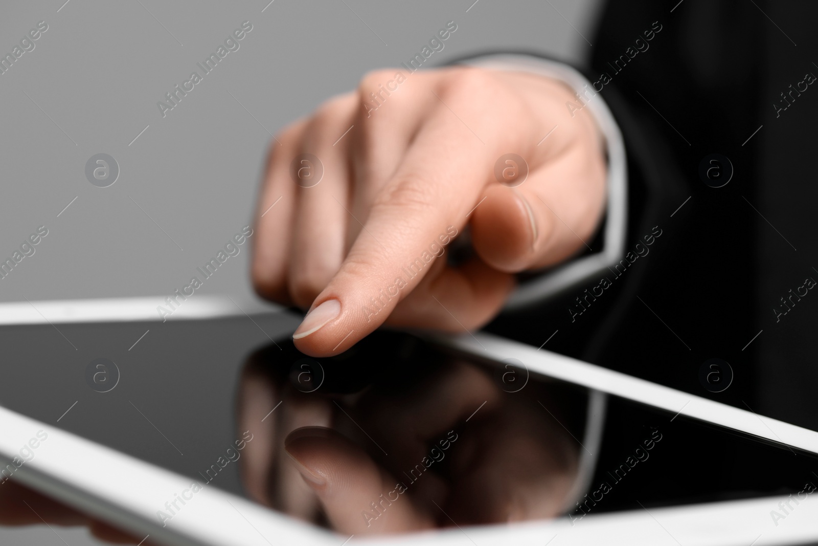 Photo of Closeup view of woman using modern tablet on grey background