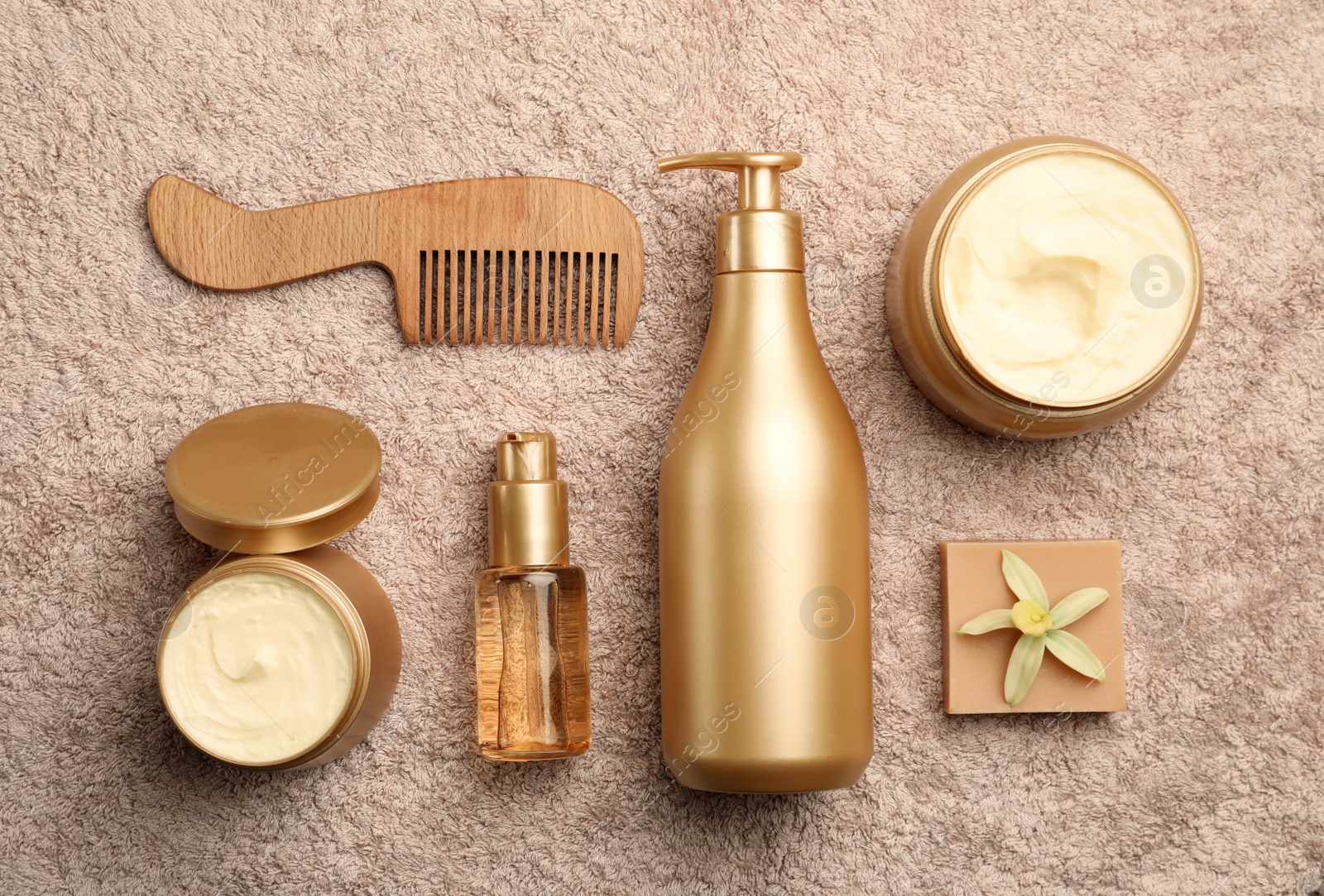 Photo of Flat lay composition with hair cosmetic products on towel