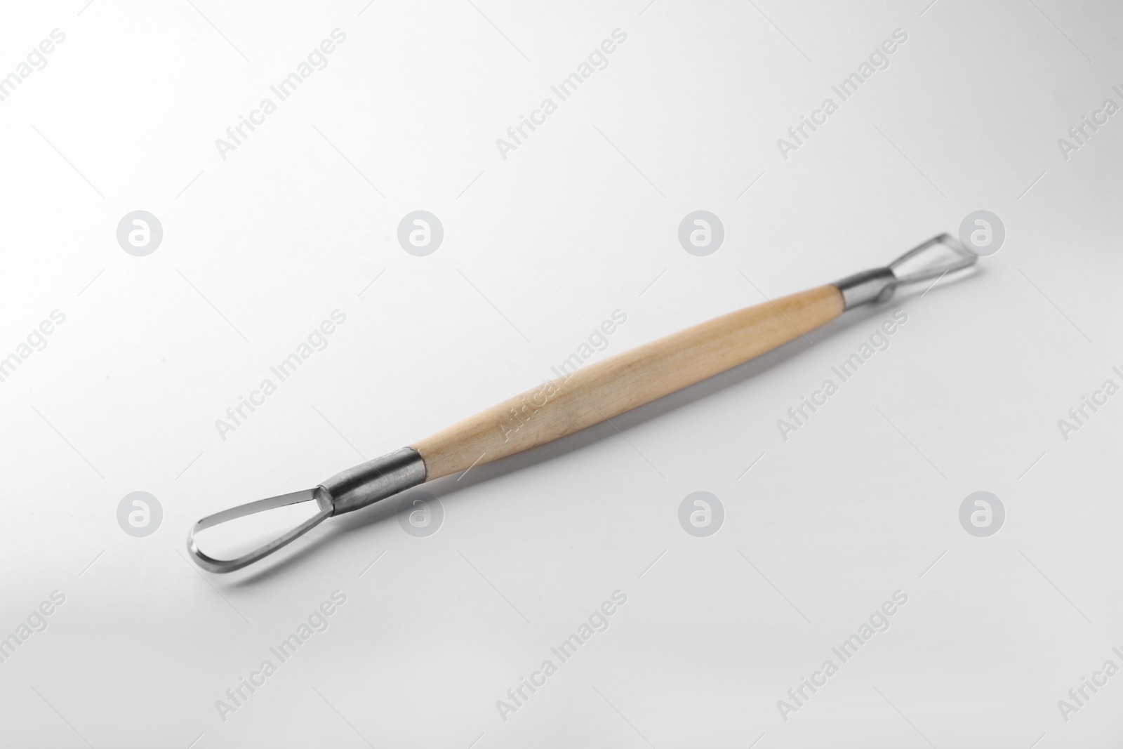 Photo of Ribbon tool for clay modeling on white background