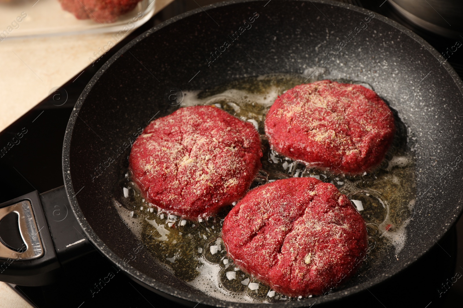 Photo of Cooking vegan cutlets in frying pan on stove, closeup