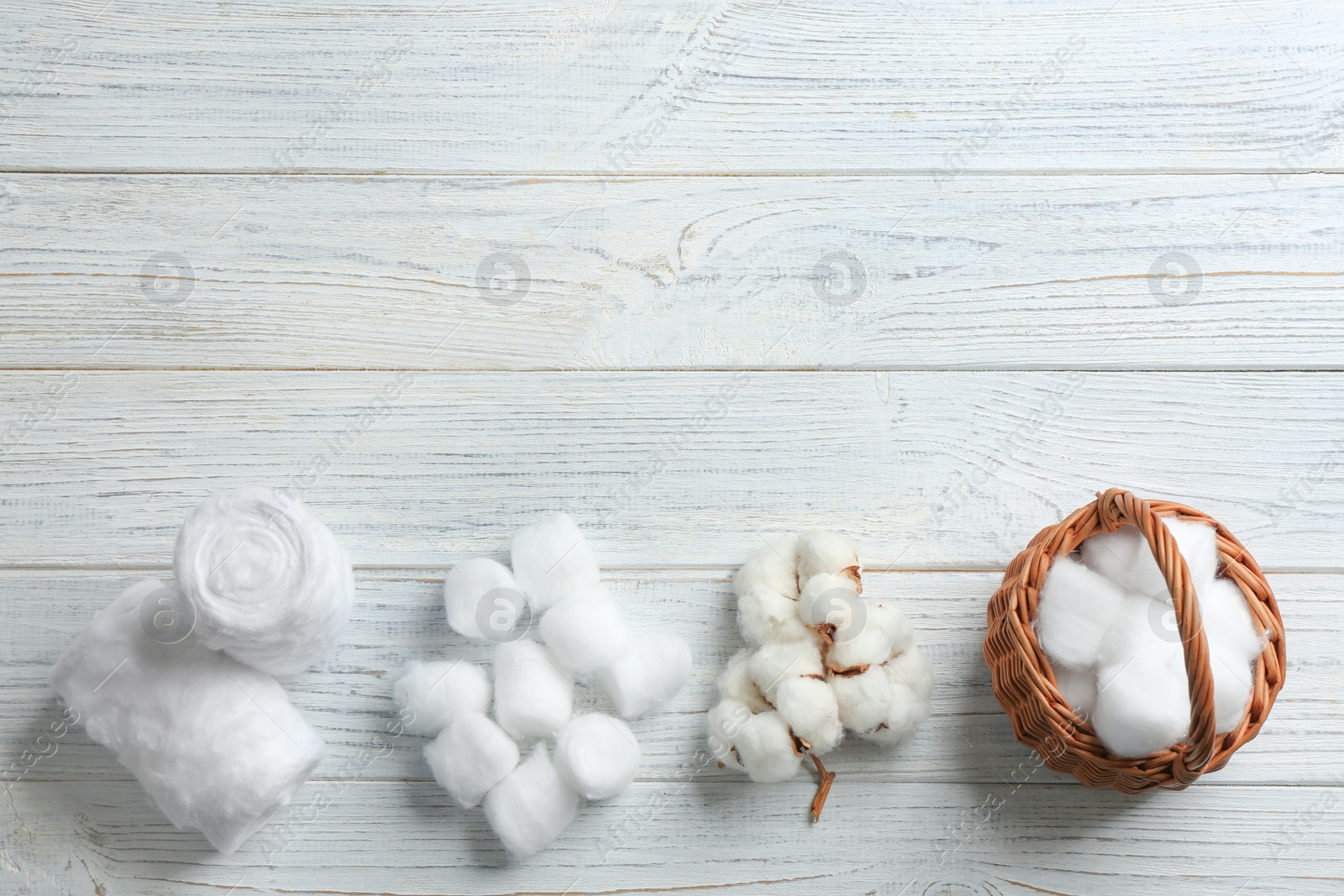 Photo of Flat lay composition with cotton balls, rolls, flowers and space for text on white wooden background