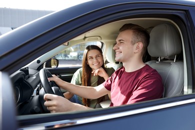 Photo of Happy young couple travelling together by car