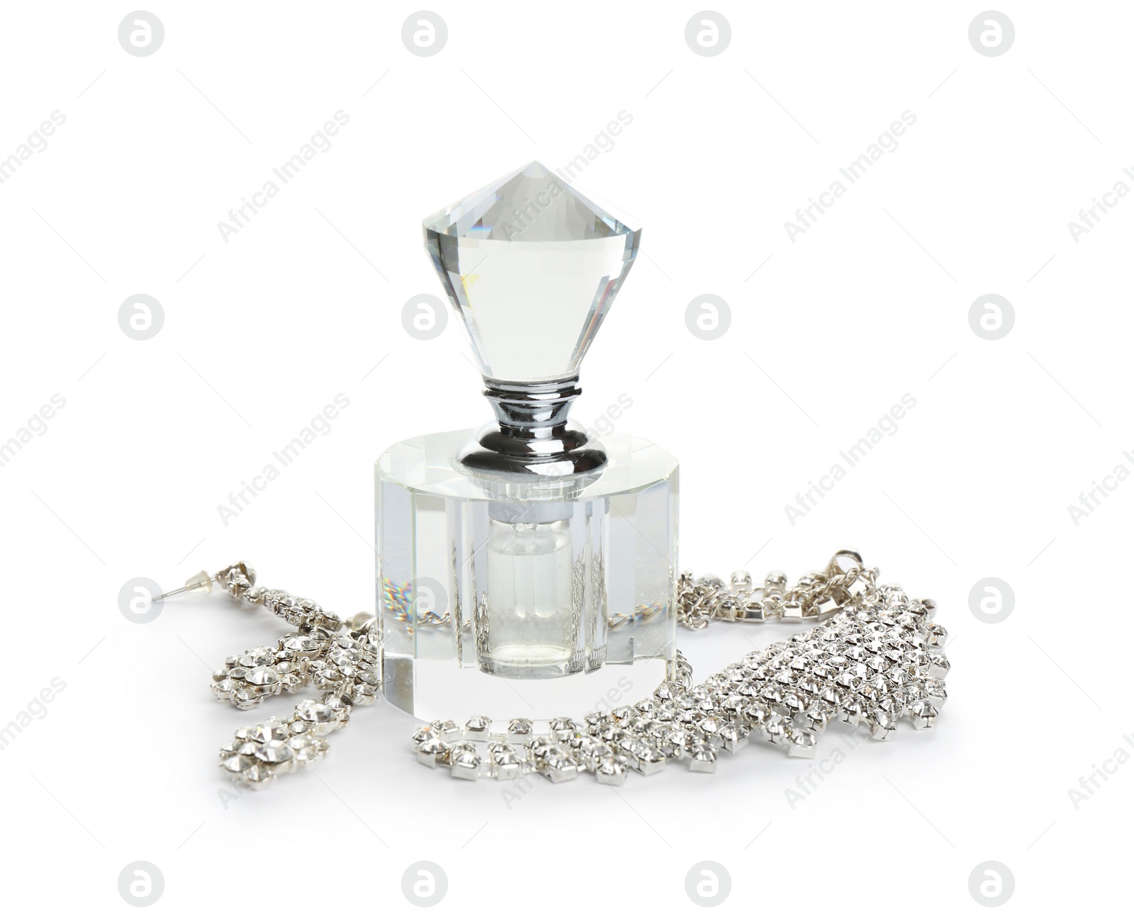 Photo of Glass bottle of perfume and luxury jewellery isolated on white