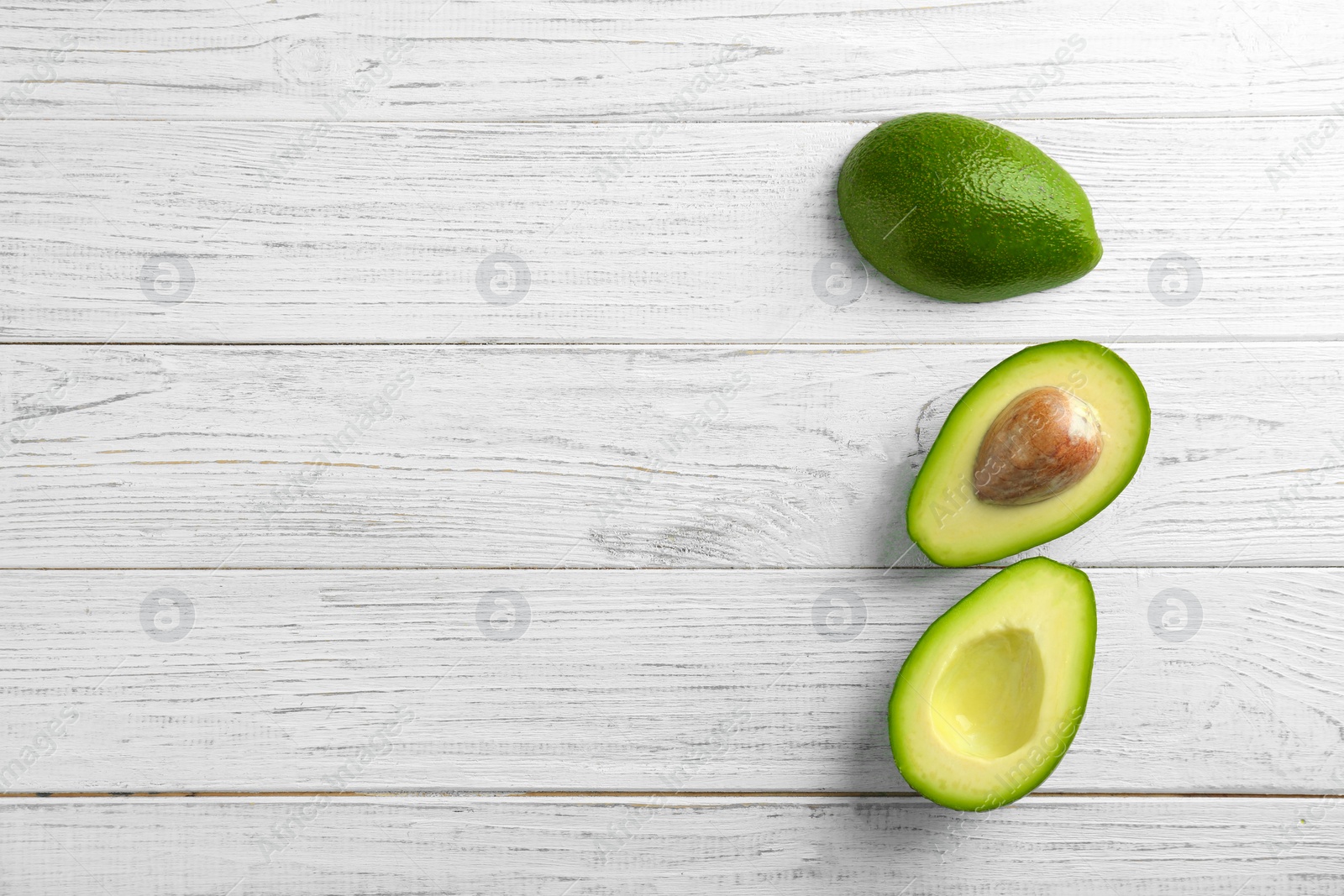 Photo of Tasty ripe green avocados on wooden background, top view