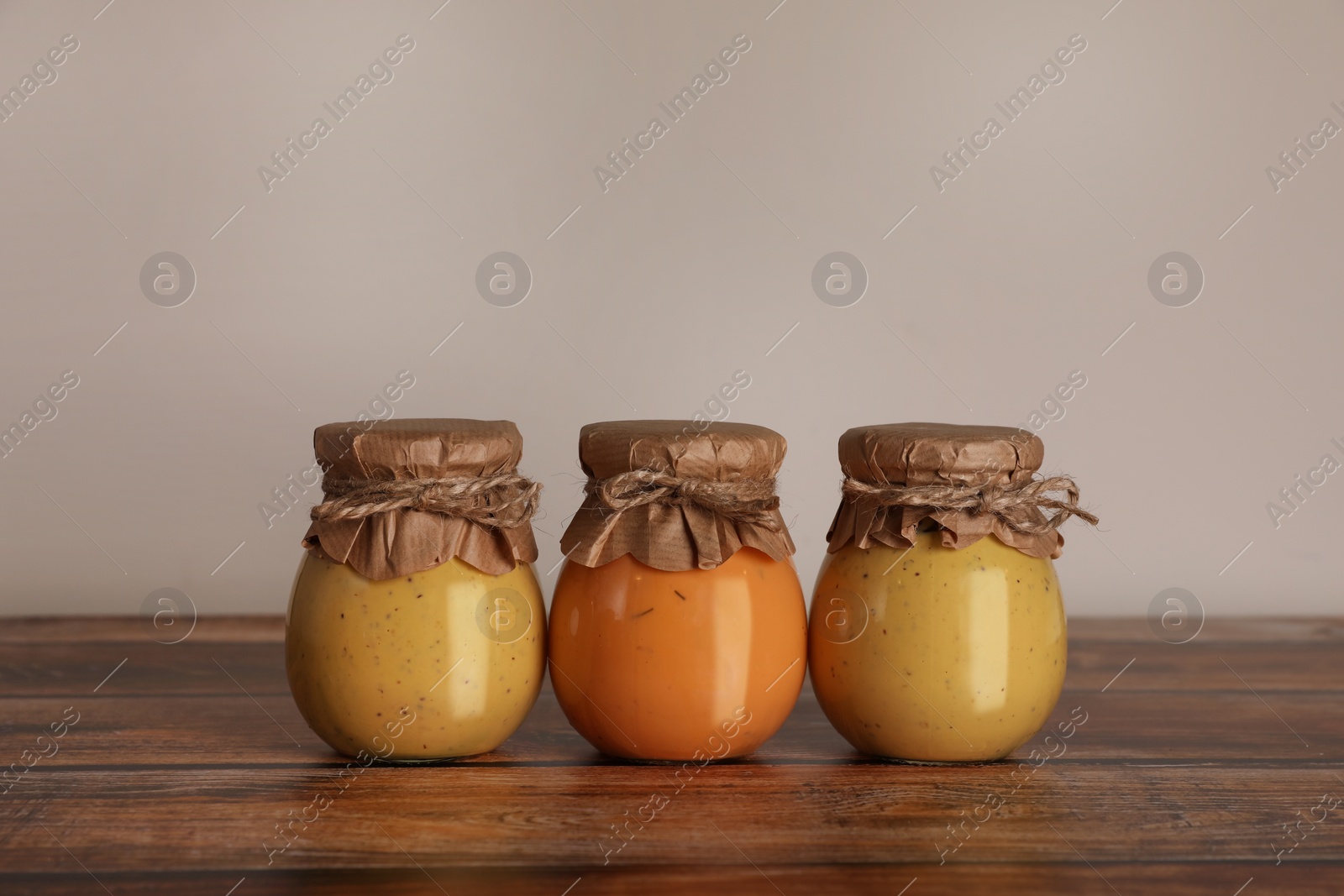 Photo of Jars with preserved fruit jams on wooden table