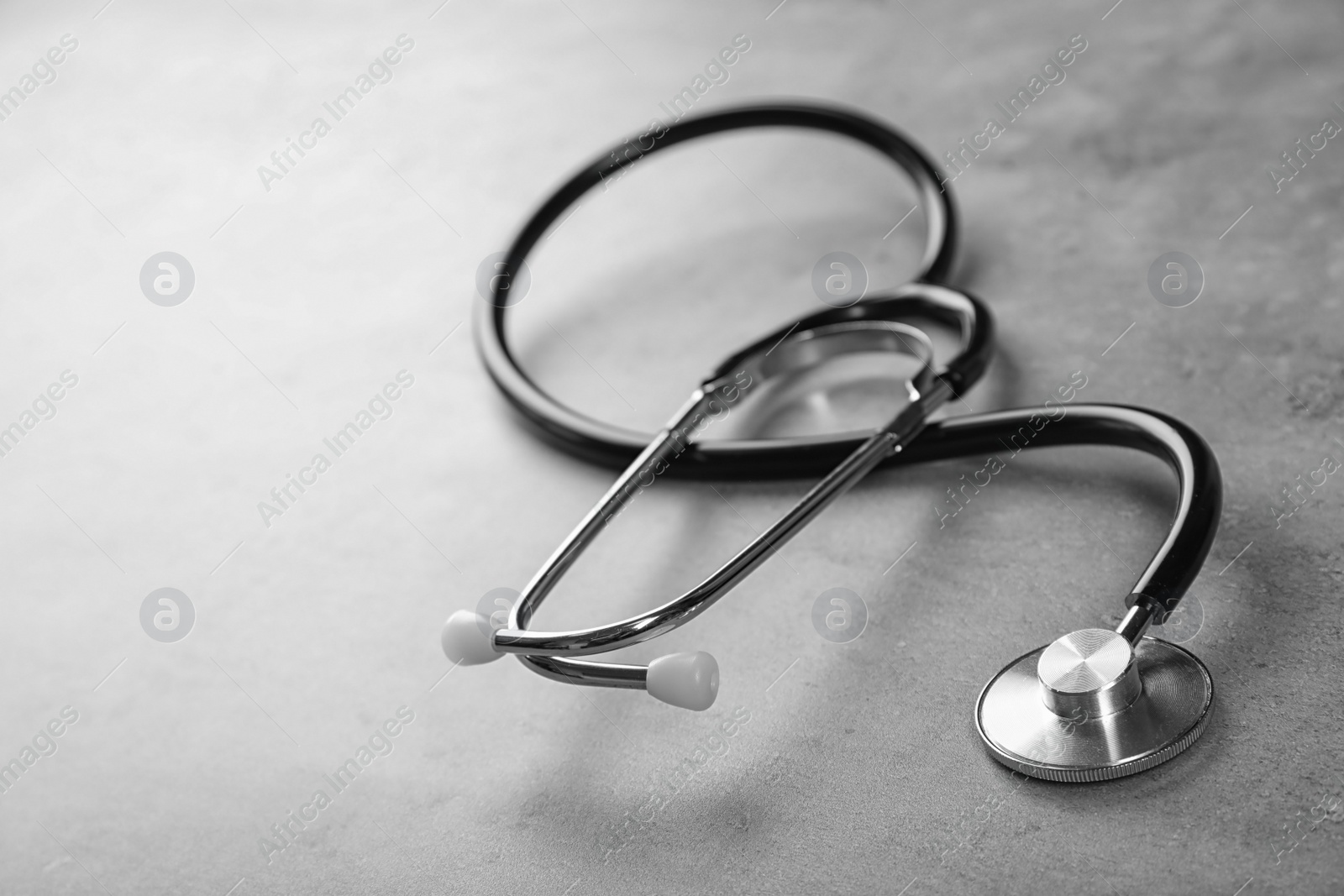 Photo of Stethoscope for checking pulse and space for text on gray background