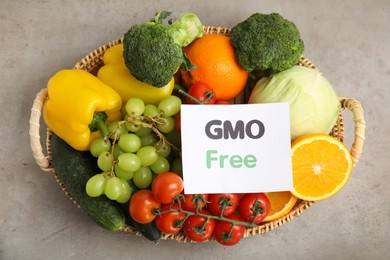Photo of Tasty fresh GMO free products and paper card on light grey table, top view