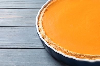 Photo of Fresh delicious homemade pumpkin pie and space for text on wooden background