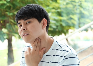 Young man checking pulse on blurred background