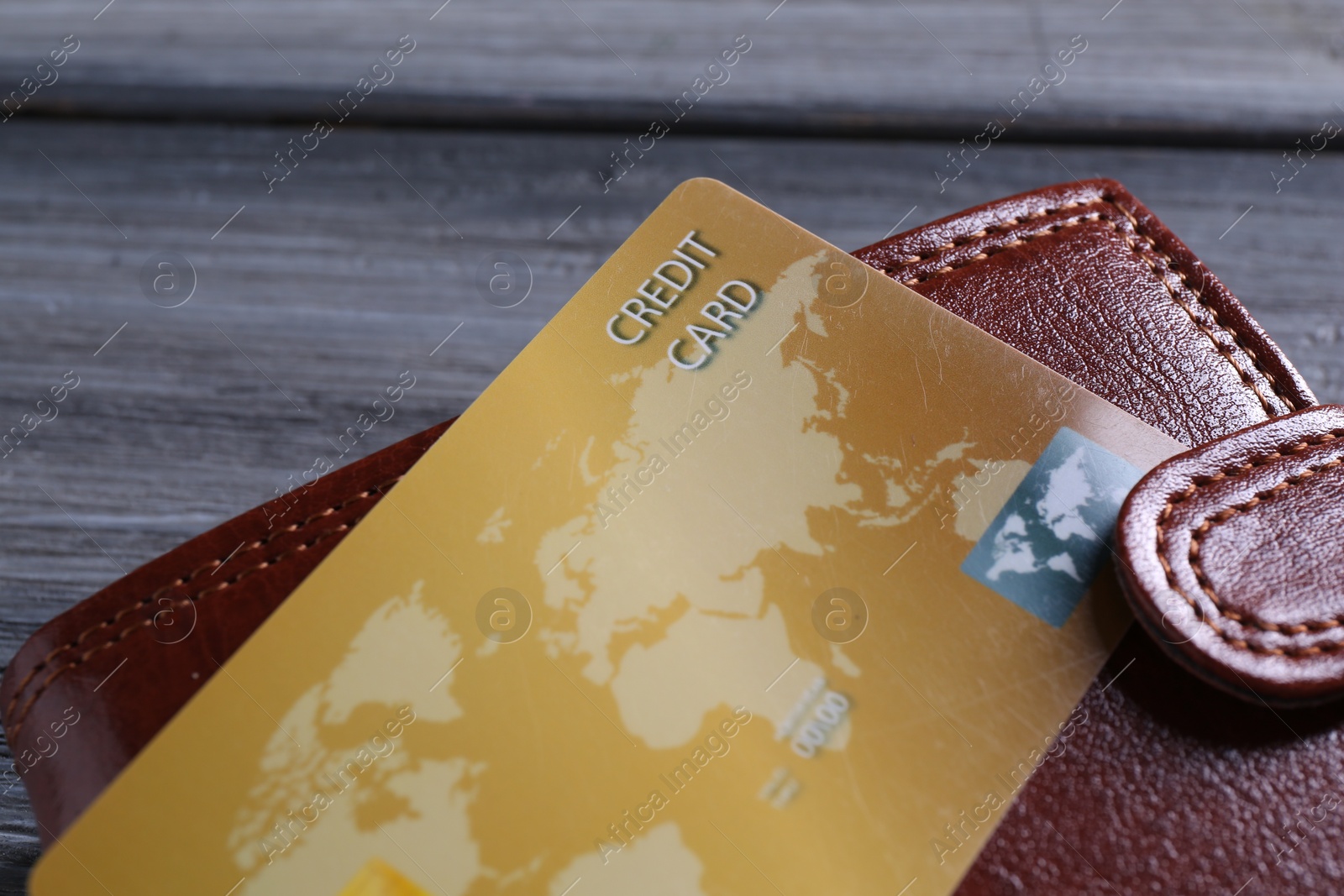 Photo of Credit card and leather wallet on grey table, closeup