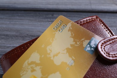 Photo of Credit card and leather wallet on grey table, closeup