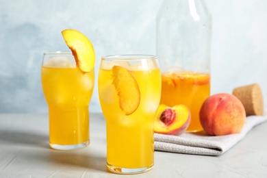 Photo of Tasty peach cocktail in glasses on table. Refreshing drink