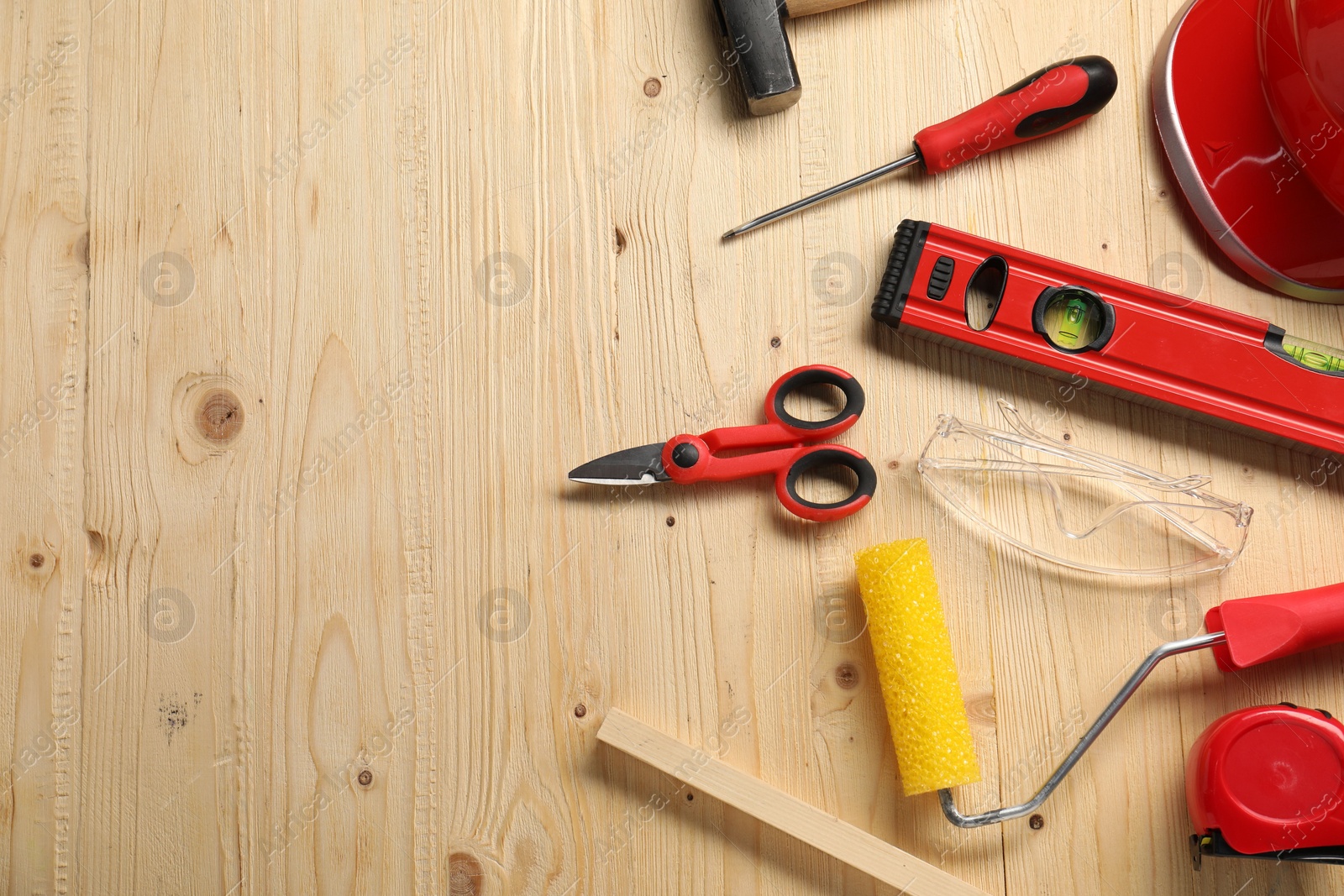 Photo of Flat lay composition with building level and other different construction tools on wooden background, space for text