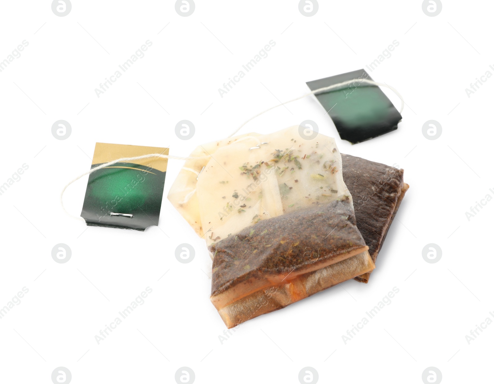 Photo of Used tea bags with tags on white background