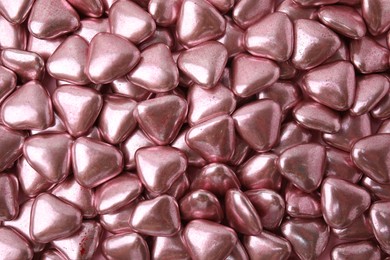 Photo of Many delicious heart shaped candies as background, top view