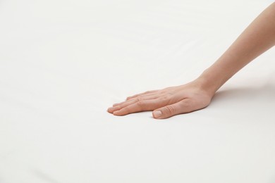 Woman touching orthopedic mattress, closeup. Space for text