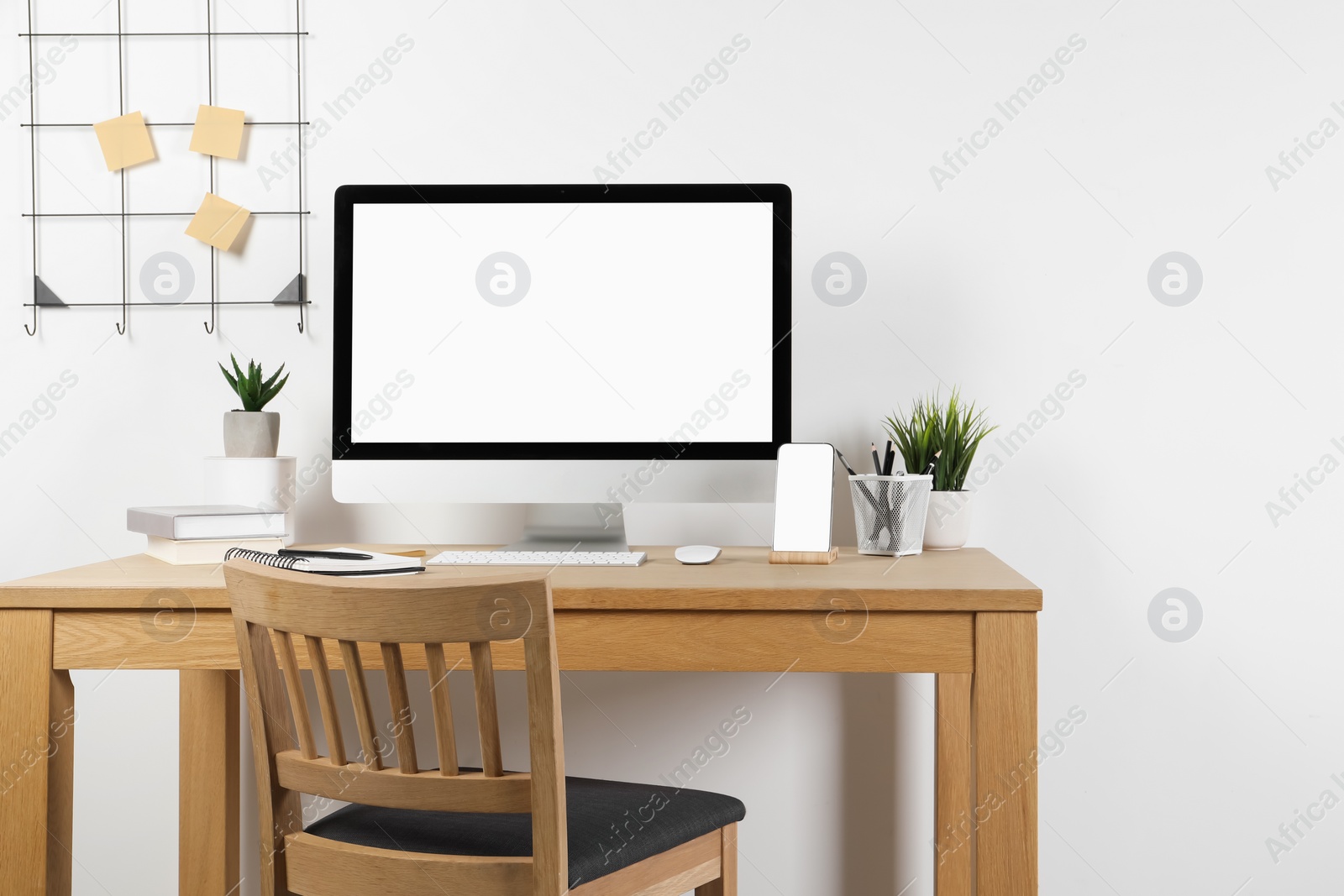 Photo of Cozy workspace with computer and stationery on wooden desk at home