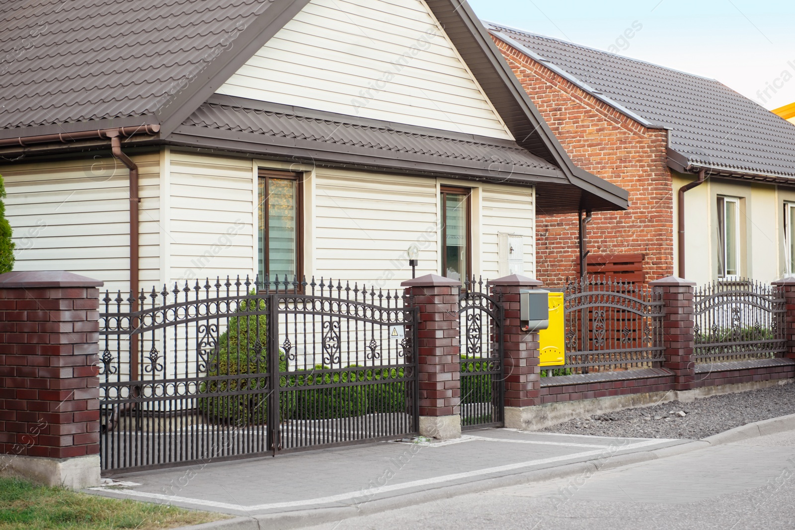 Photo of Houses behind beautiful fence near road outdoors