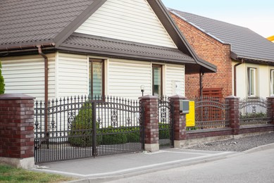 Houses behind beautiful fence near road outdoors