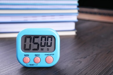 Kitchen timer on wooden table, closeup. Space for text