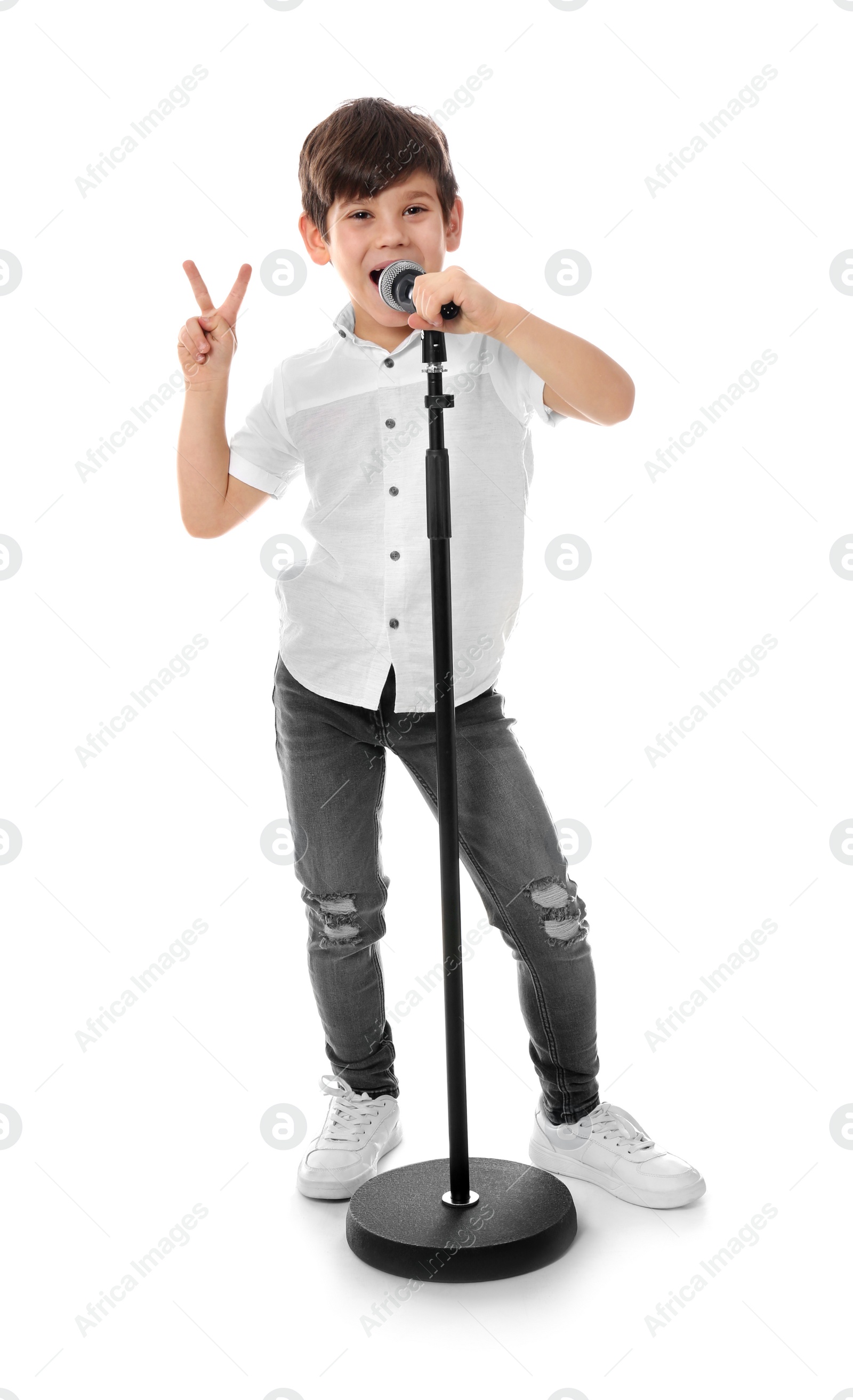 Photo of Cute little boy singing into microphone on white background