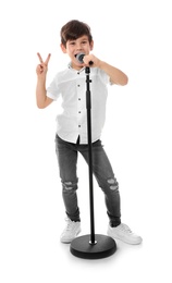 Photo of Cute little boy singing into microphone on white background