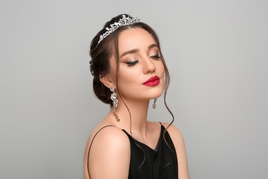 Photo of Beautiful young woman wearing luxurious tiara on light grey background