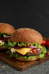 Photo of Delicious burgers with beef patty and lettuce on grey table