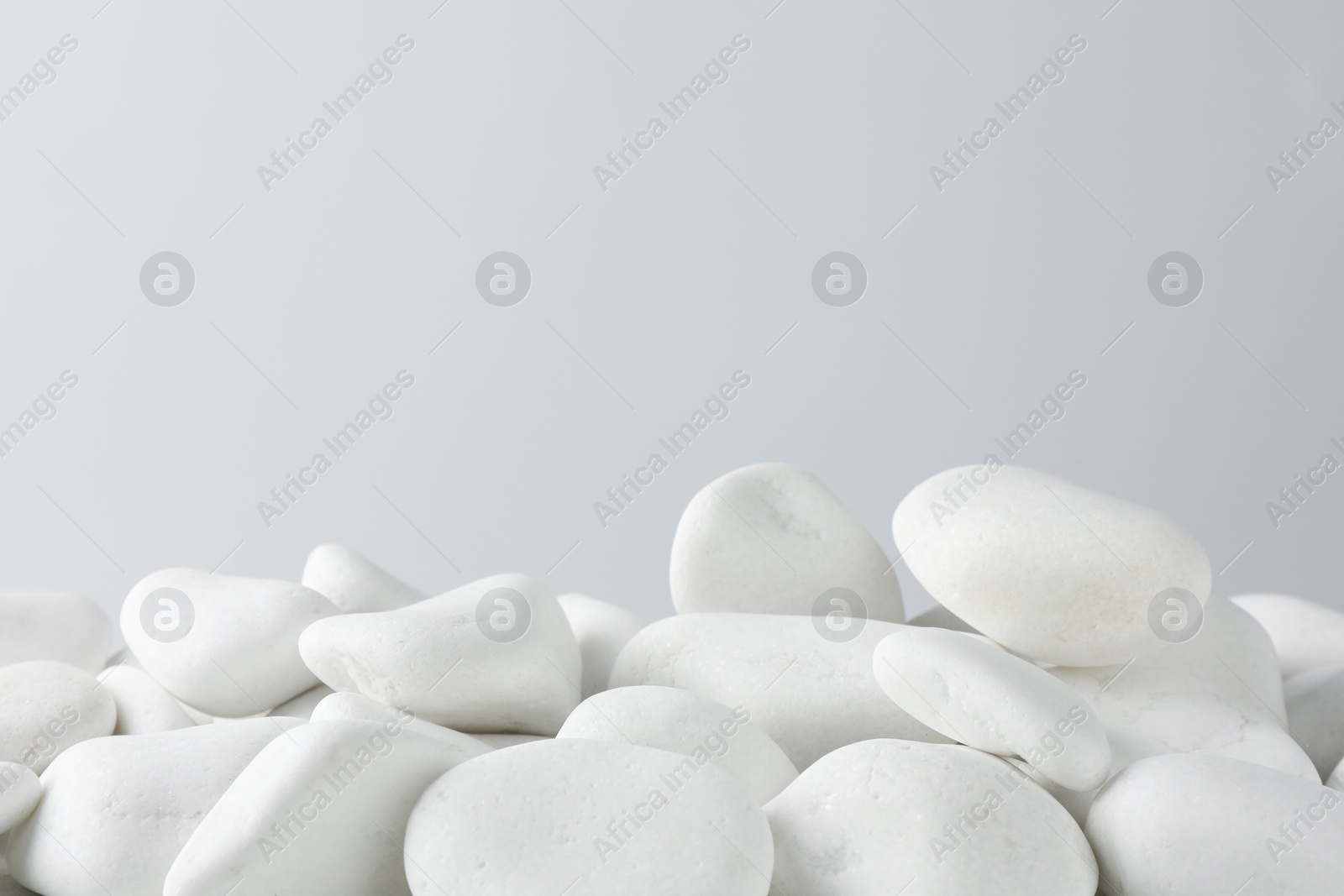 Photo of Presentation for product. White pebbles on light background. Space for text