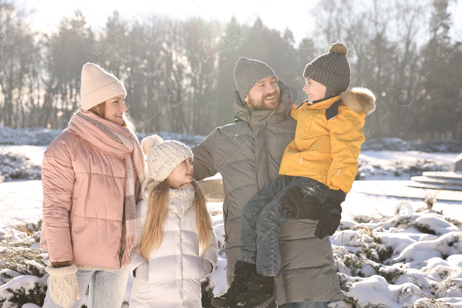 Photo of Happy family spending time together in sunny snowy park