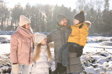 Happy family spending time together in sunny snowy park