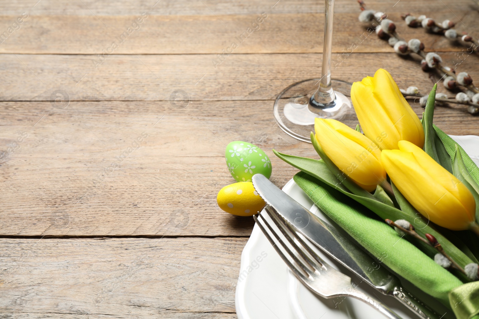 Photo of Festive Easter table setting with floral decor on wooden background, closeup. Space for text