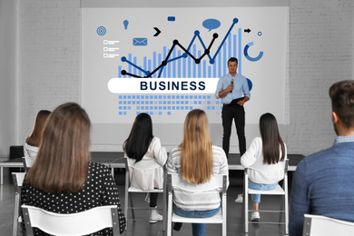 Image of Business trainer giving lecture in conference room with projection screen