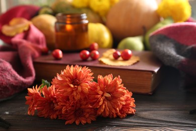 Photo of Beautiful orange chrysanthemum flowers on wooden table, space for text. Autumn still life