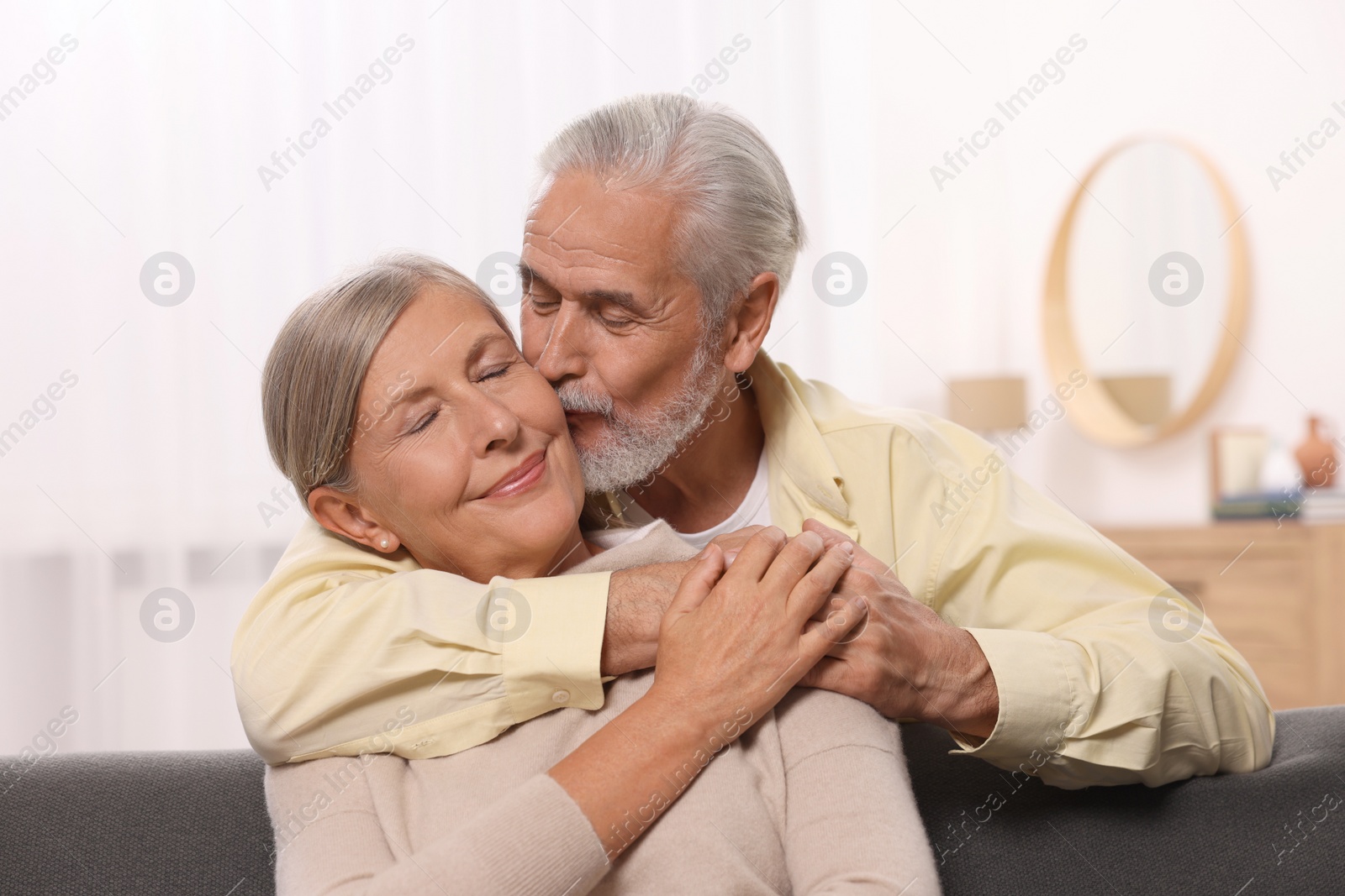 Photo of Senior man kissing his beloved woman at home