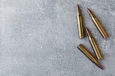 Photo of Bullets on light grey table, flat lay. Space for text