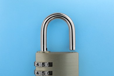 Photo of Steel combination padlock on light blue background, top view