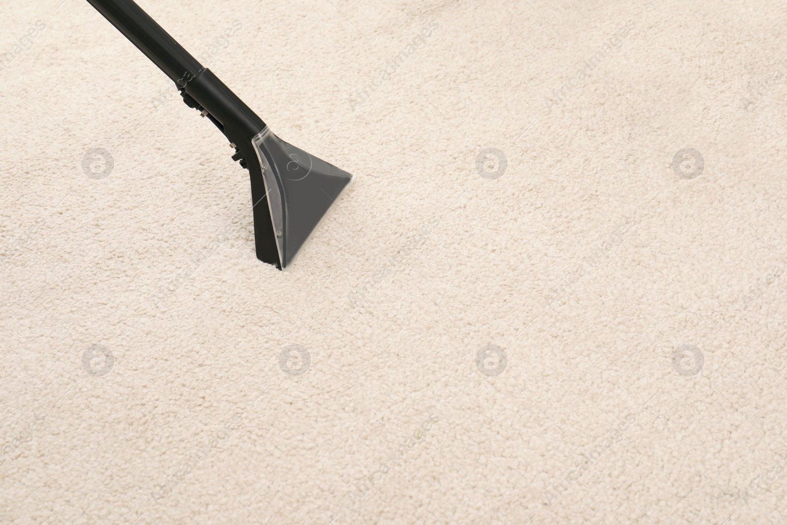 Photo of Removing dirt from carpet with vacuum cleaner indoors, closeup. Space for text