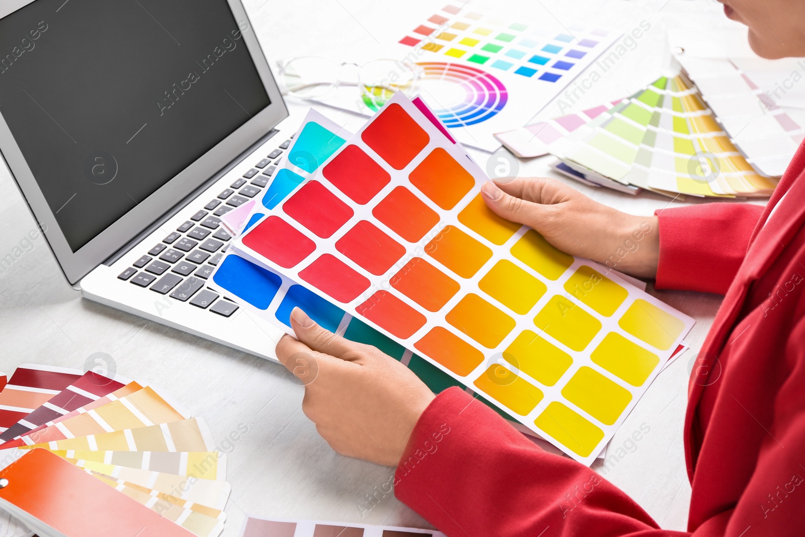 Photo of Woman with palette samples at white table, closeup