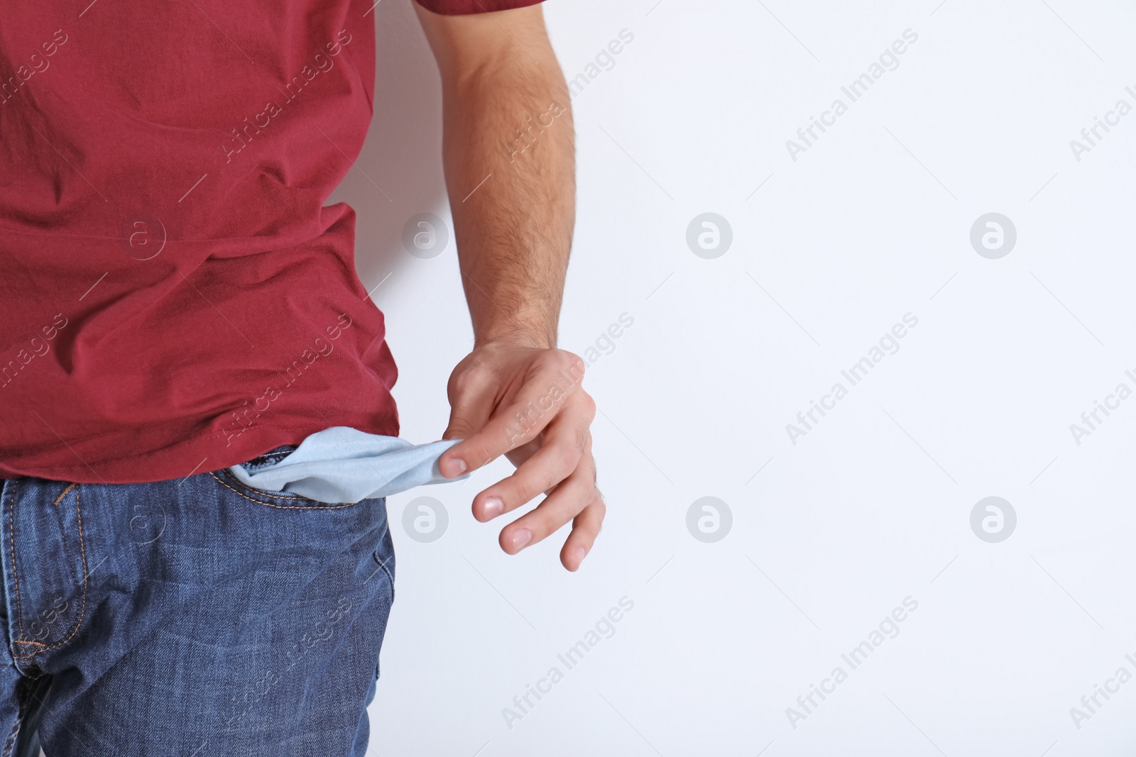 Photo of Man showing empty pocket on light background, closeup with space for text