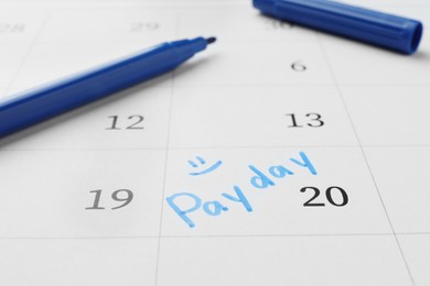 Blue felt pen on calendar page with marked payday date, closeup